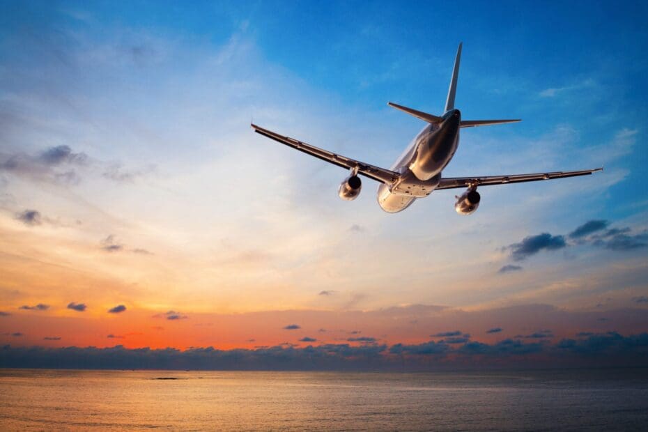 Airplane flying the friendly skies above a tropical sea at sunset